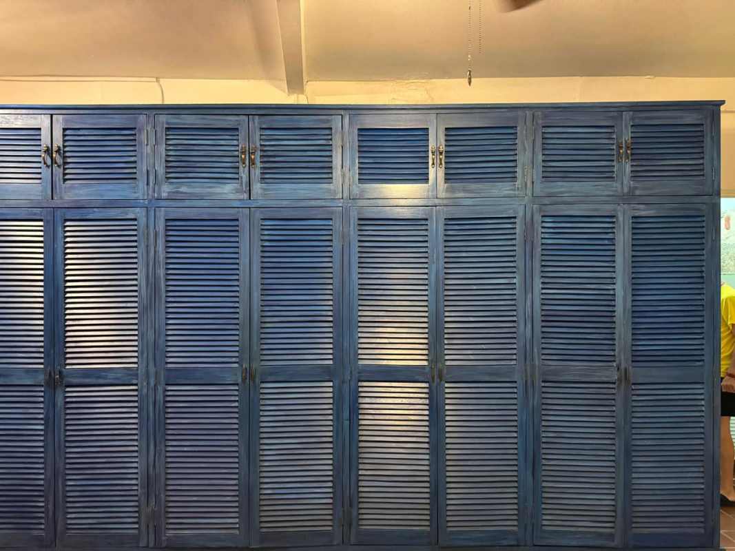 Bedroom loft with large blue louvered closet and exposed stone Casco Viejo Panama