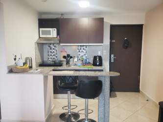 Kitchen with granite counters microwave and bar seating at PH Ibiza Playa Corona Panama apartment