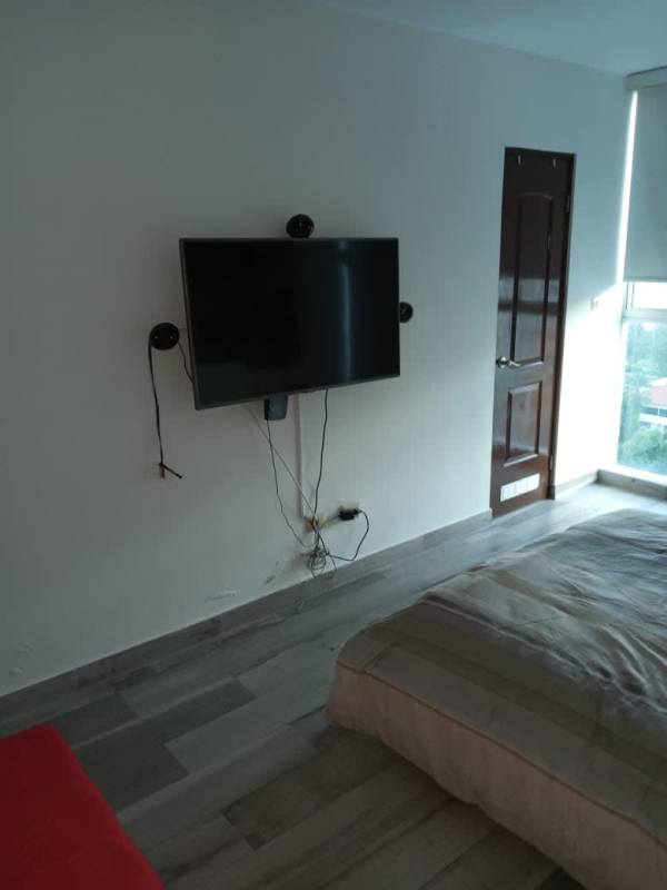 Bedroom with wooden furniture and red bedding in PH Pacific Sky Panama