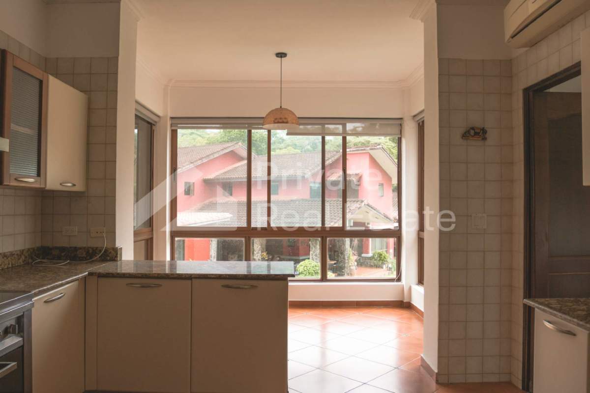 Modern kitchen with granite countertops, tiled walls, large windows in Camino de Cruces house Panama