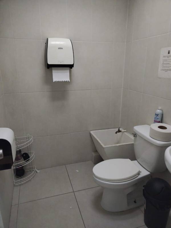 Bathroom with toilet, bidet, gray tiles and paper holder at Edison Corporate Panama City