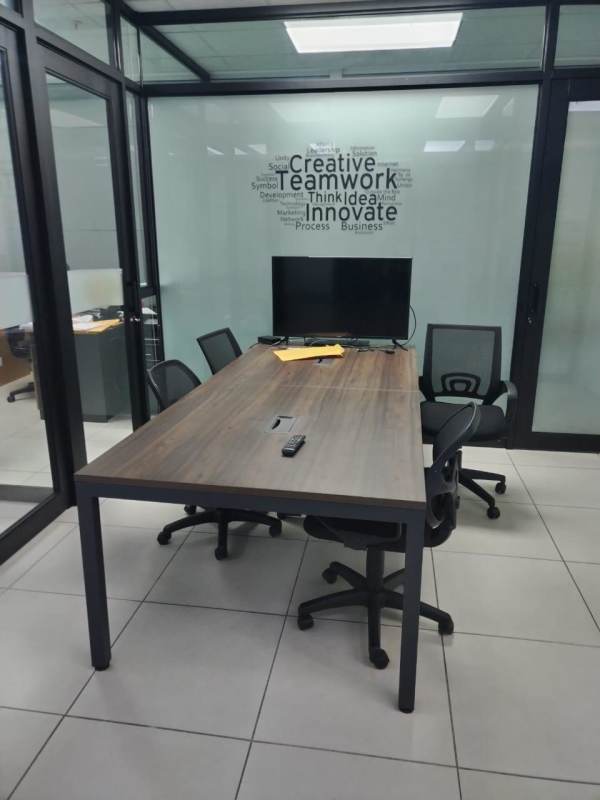 Large wooden conference table with glass walls and flat screen in Edison Corporate Panama