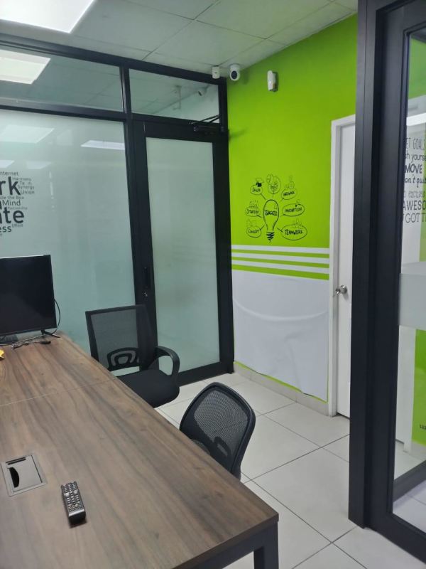Workspace with glass wall, shelving, and window view at Edison Park Panama