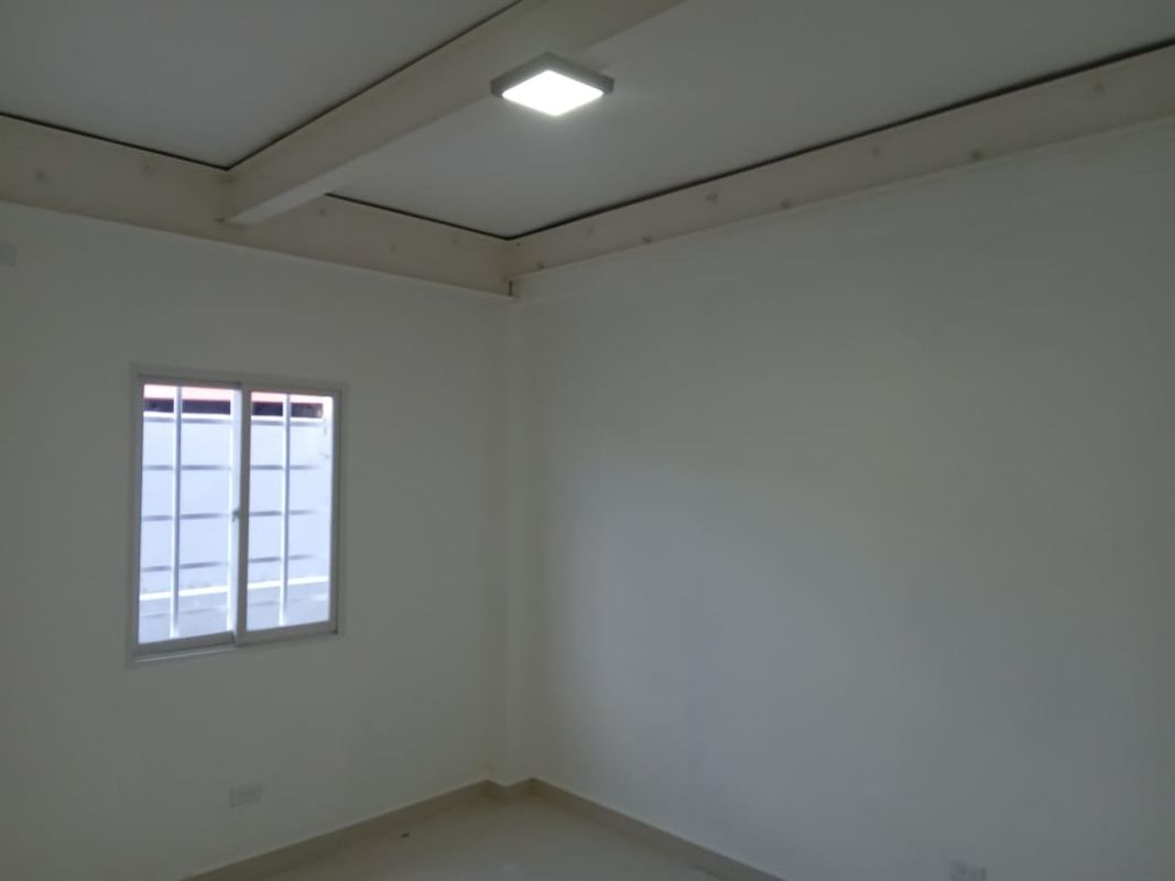 Minimalist empty room with white walls, white ceiling, windows and tiled floor in Vista Hermosa business center