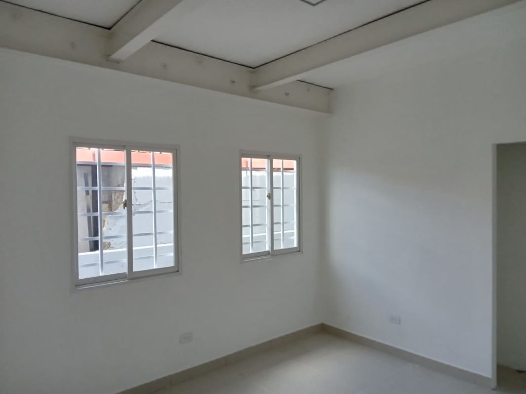 Office interior with two sliding windows, exposed beams, white walls in Vista Hermosa for rent