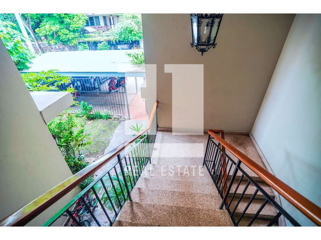 Spacious living room with large sliding doors, wooden ceilings, balcony overlooking garden La Cresta Panama