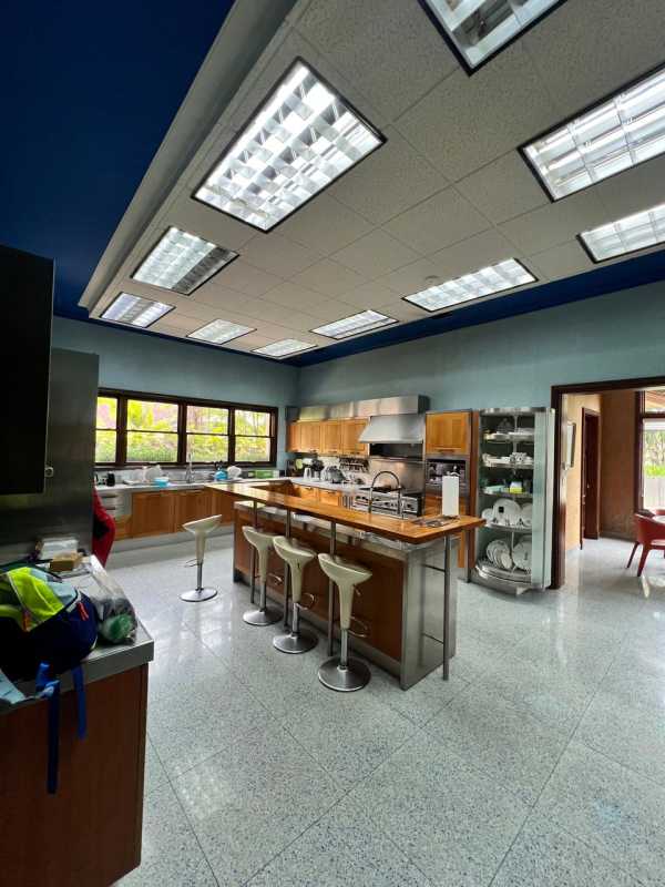 Designer kitchen with large island, stainless appliances, wood cabinetry at mansion in Altos del Golf, Panama City