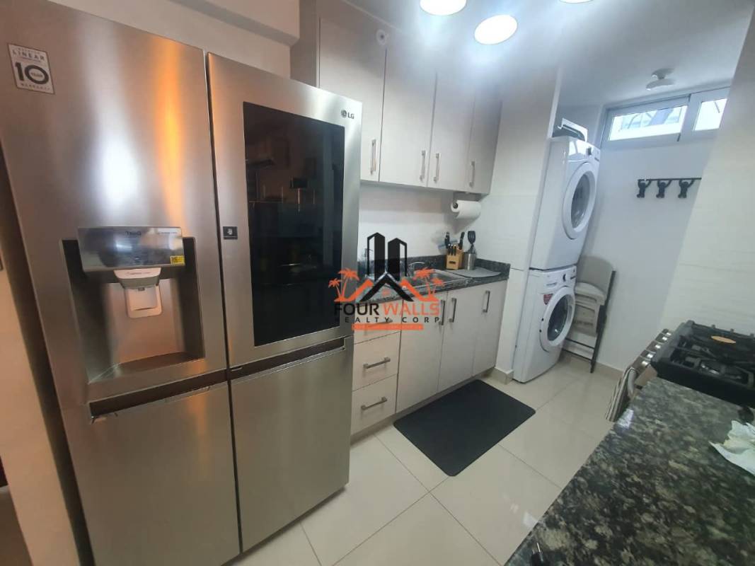 Modern kitchen equipped with granite countertops, appliances, and laundry at PH Park Point Panama