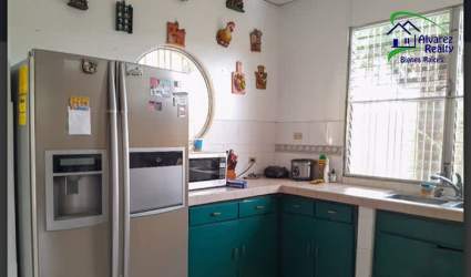 Living room with sectional sofa, stone accent wall, and greenery in Chiriquí house