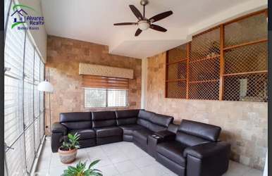 Guest bedroom with large windows and ceiling fan in family house Volcán Panama