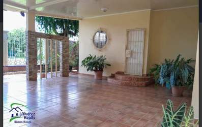 Living room area with spiral staircase, tiled floor, sectional sofa and entertainment center in David Chiriquí
