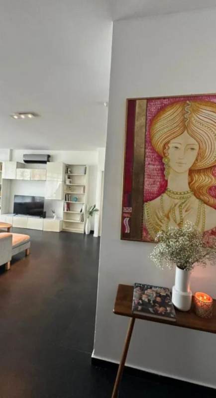 Modern living room setup in PH Marina Park with wall art, sofa, built-in shelving, TV