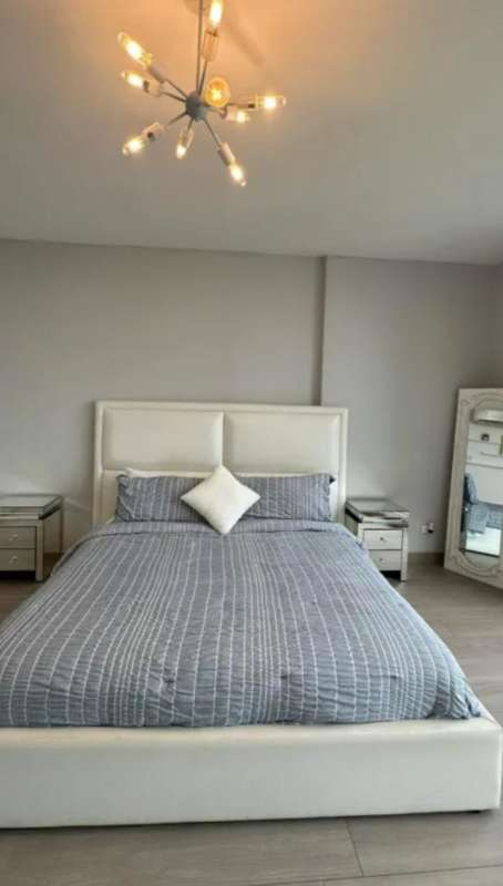 Bedroom with large windows, pendant light, city skyline view PH Marina Park Panama