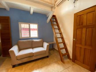 Spacious living room with vaulted wooden beam ceiling, fan, tile floor in beach house at Coronado Panama