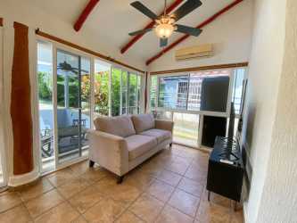 Enclosed sunroom with sliding glass doors, bright space overlooking garden in Club Ecuestre