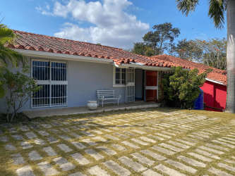 Single-story house with terracotta tiled roof lush garden at Club Ecuestre near Coronado Panama