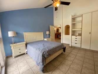 Bedroom with blue accent wall, ceiling fan, built-in closet garden view Coronado Panama