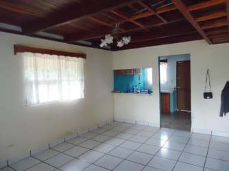 Rustic living room with wood ceiling beams, tile flooring and large window mountain cabin Paso Ancho