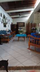 Traditional living room with exposed beams, tile floor, and wooden furniture in San Antonio Panama house