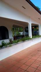 Covered outdoor veranda with arches, flower beds and terracotta flooring in house for rent David Panama