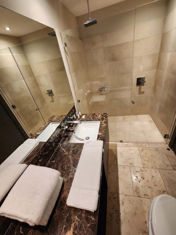 Modern marble bathroom with glass shower enclosure luxury rental at JW Marriott Punta Pacifica Panama