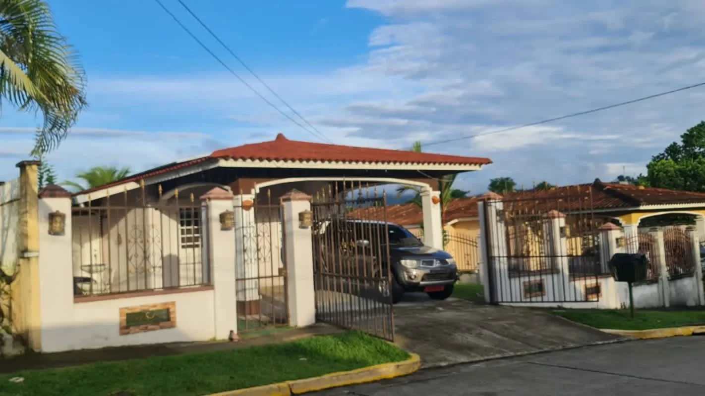 Exterior of house with fenced yard, palm tree, driveway Villa Zaita Panama