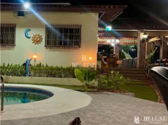 Night view of home exterior with pool, patio and gardens in El Higo Panama