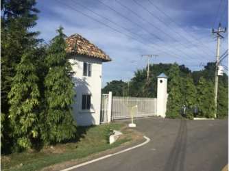 Controlled tree-lined gated entrance with security booth at Sol y Mar Río Hato Coclé Panama