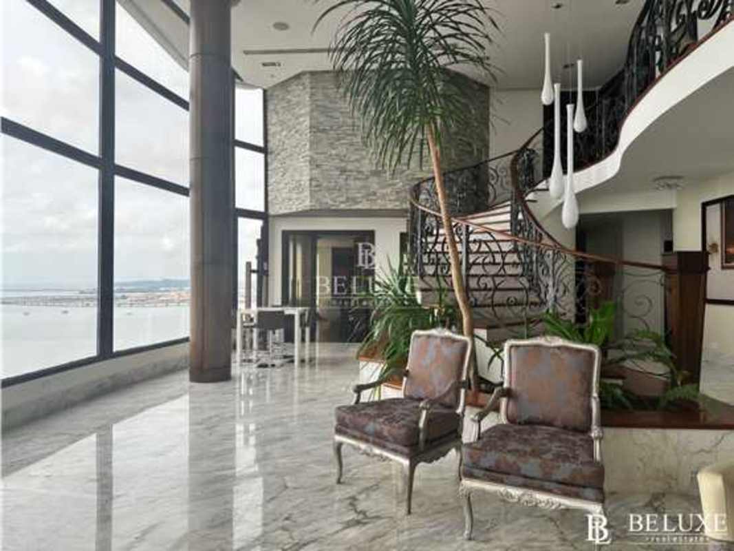 Luxury penthouse interior with marble floors, panoramic ocean windows, elegant stairs in Punta Paitilla Panama
