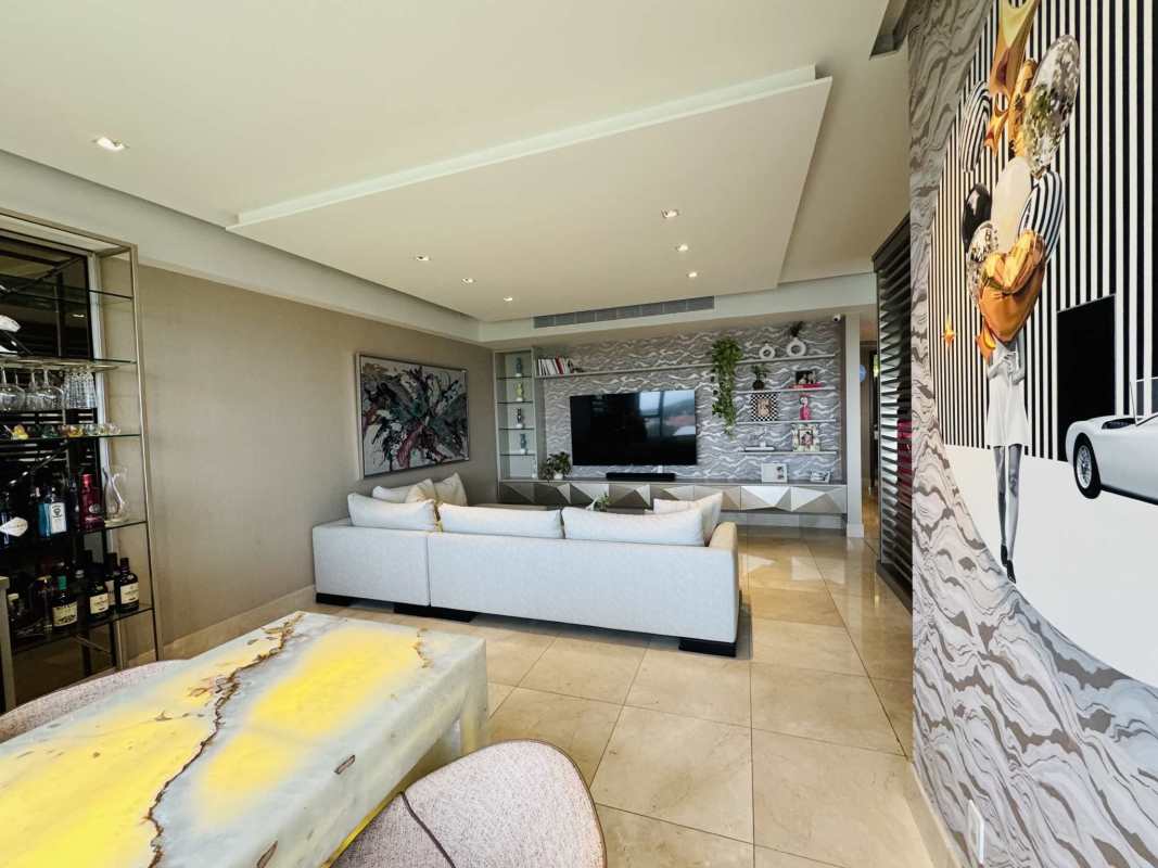 Spacious modern living room with textured feature wall, sectional sofa, dining area in PH Vitta Santa Maria Panama