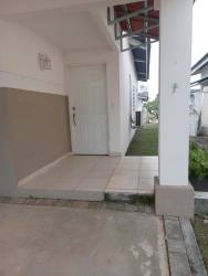 Covered porch with tiled entry and lawn in beach house Playa Dorada Panama