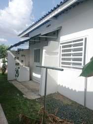 Green lawn with metal awning and flowerbeds outside house for sale near Playa Dorada beach Panama