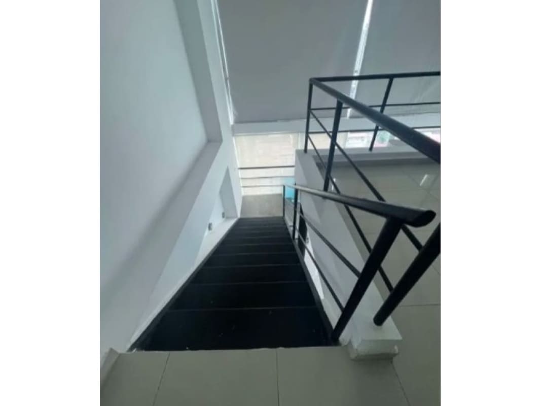 Open space living area with large sectional sofa and stairway loft at PH Vitro, Panama City