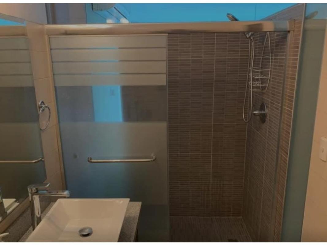 Stylish bathroom with glass-enclosed walk-in shower in PH Vitro Panama City