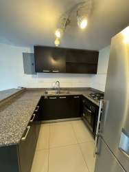 Kitchen with granite counters, dark cabinets, and stainless steel appliances in Panama Pacifico