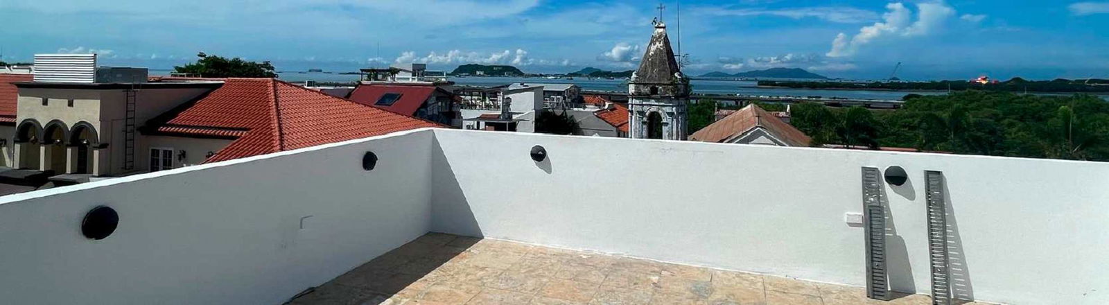Rooftop terrace with white walls sea views city skyline Casco Viejo Panama