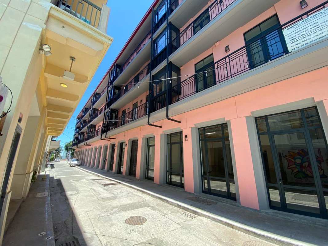 Exterior view multistory colonial mixed-use building with colorful facades and retail storefronts at La Quince Santa Ana Casco Antiguo Panama City