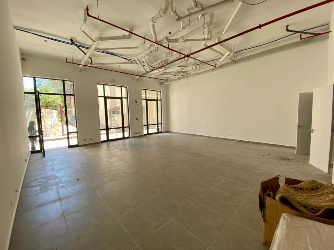 Spacious industrial-style commercial interior with tiled floor and floor-to-ceiling windows in Santa Ana Panama