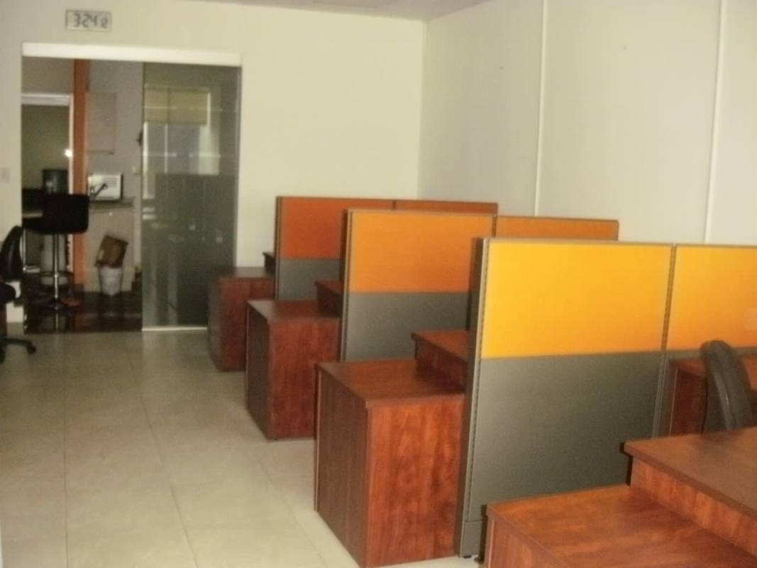 Modern cubicle area with glass separations and workstations inside Torre Banesco Banking District Panama