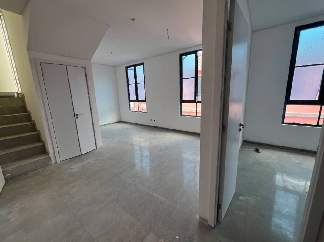 Modern open living dining room with large windows brown sofa wall art Casa Korsi Panama