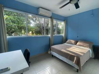 Modern bathroom beige tiles glass shower enclosure pedestal sink Nueva Gorgona Panama