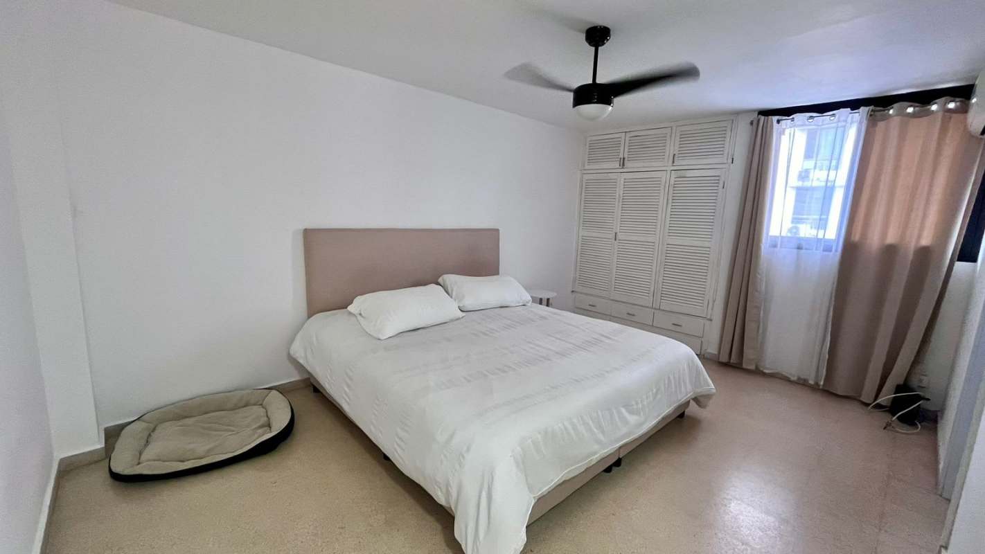 Bright bedroom with large window, city view and neutral design PH Liz Marie Panama City