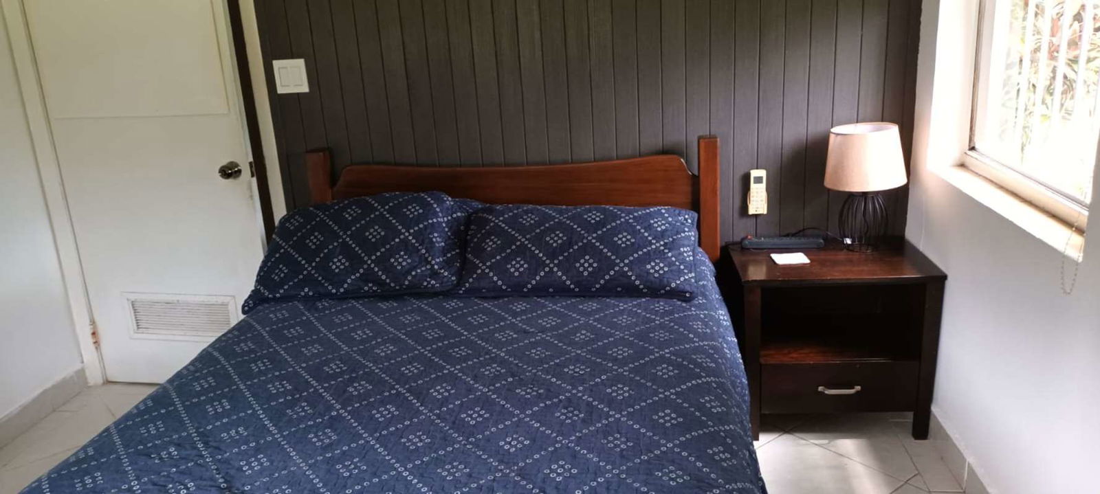 Rental bedroom with blue bedding, AC, TV near City of Knowledge Panama