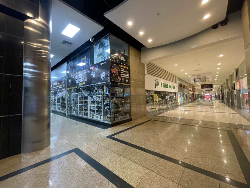 Wide mall corridor with storefronts under bright lighting at Dorado Super Center in El Dorado Panama City
