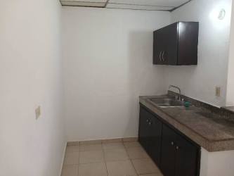 Compact kitchen with dark cabinets and tiled floor in affordable La Herradura apartment rental Panama