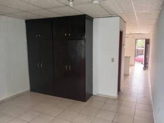 Front exterior blue painted wall, metal security gate, window with rental sign in affordable La Herradura apartment Panama Oeste