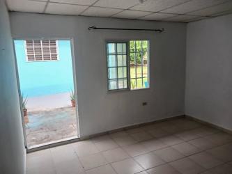 Living room with tiled floor, open patio door and window at La Herradura apartment rental Panama Oeste
