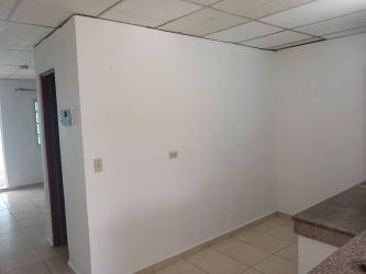 Interior with white walls, tiled floor, and partial kitchen view in La Herradura apartment rental Panama Oeste
