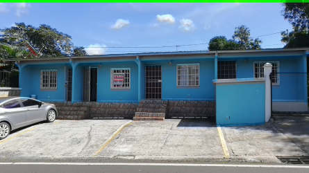 Blue single-story house with barred windows, secured metal doors and parking area, Residencial La Herradura La Chorrera