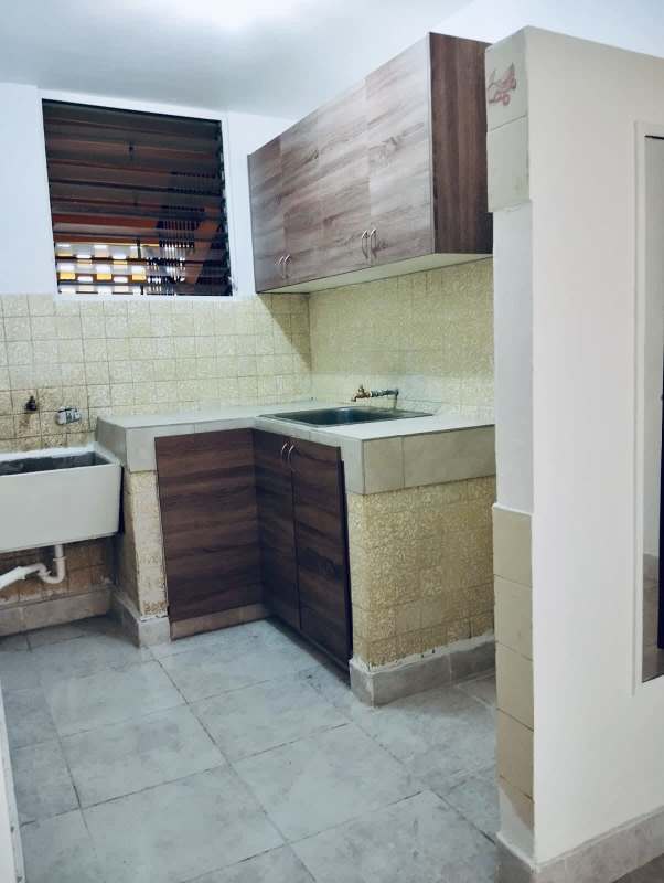 Simple kitchen with tiled backsplash, window and sink in PH El Ingenio Residences Panama